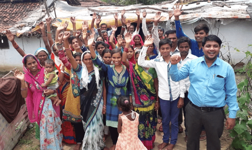 A group of people standing in the street in South Asia raising their hands