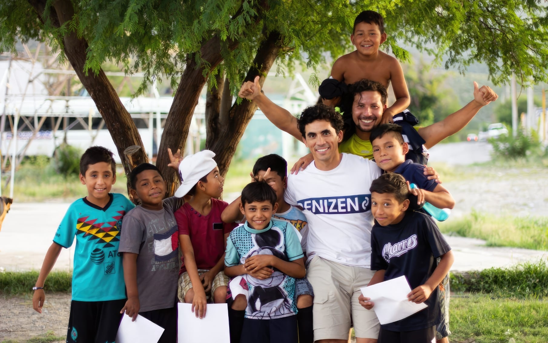 A man with teenage boys hugging and smiling at the camera