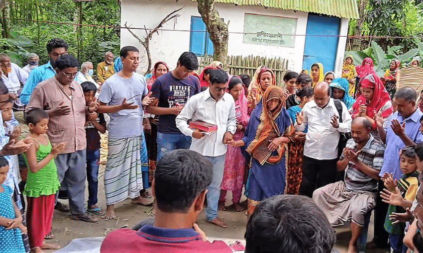 Native Bengali believers standing in a circle and holding hands while praying. Reaching the Finish Line: Bengali Believer Remains Faithful to the End Despite Many Challenges