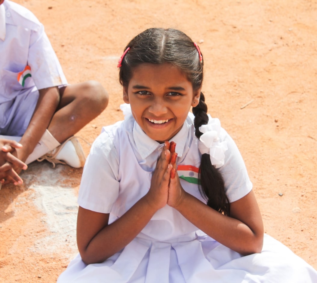 Girl Praying while sitting on the ground in a school dress